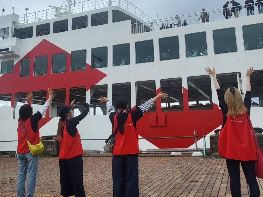 "瀬戸内国際芸術祭2025でフェリーを見送る案内スタッフの様子"